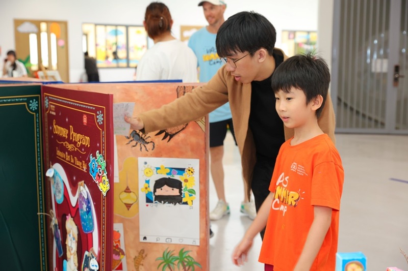 A person and child looking at a displayDescription automatically generated